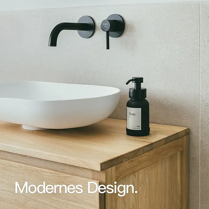 Designfabrik Hamburg Seifenspender - Edelstahl, Schwarz/Schwarz beschichtetes Glas - Elegantes Badezimmer-Design mit schwarzem Steinberg-Wasserhahn und einer stilvollen Seifenflasche auf einem Holzwaschtisch.