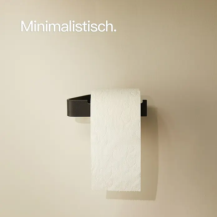 Designfabrik Hamburg Toilettenpapierhalter - Schwarz, Matt - Minimalistisch: Toilettenpapierhalter aus dunklem Metall mit einer Rolle weißem Toilettenpapier an einer hellbeigen Wand.