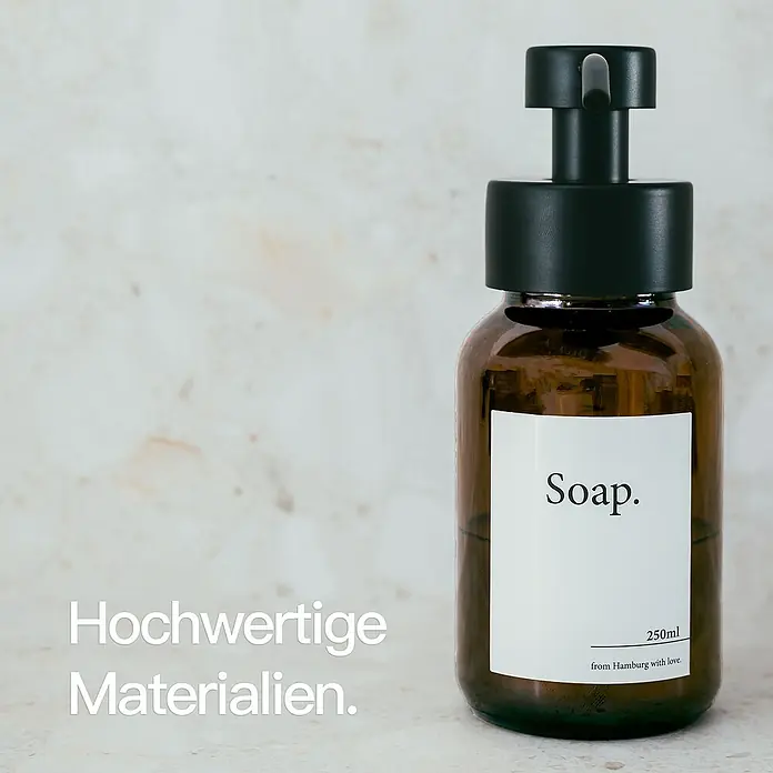 Designfabrik Hamburg Seifenspender - Edelstahl, Schwarz/Braunglas - Braune Glasseife mit schwarzer Pumpe und minimalistischem Etikett, das "Soap" und "250 ml" liest.