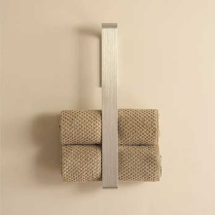 Designfabrik Hamburg Handtuchhalter - Silber gebürstet, Matt - Ein moderner Handtuchhalter aus Metall mit zwei gefalteten, beigen Handtüchern, die einen Hauch von Eleganz ins Badezimmer bringen.