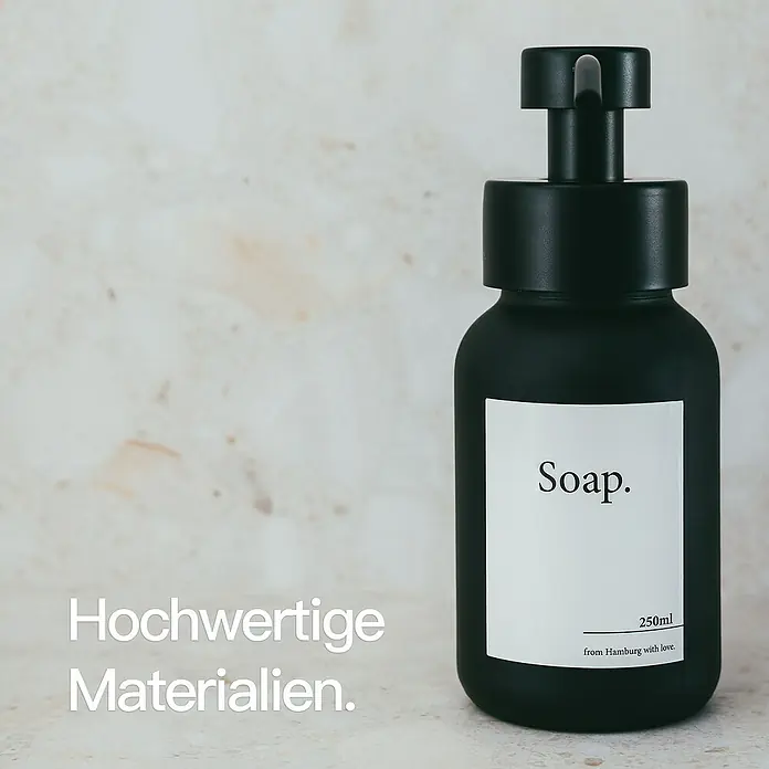 Designfabrik Hamburg Seifenspender - Edelstahl, Schwarz/Schwarz beschichtetes Glas - Schwarzer Seifenspender mit weißem Etikett und minimalistischem Design. Hochwertige Materialien für stilvolle Badezimmerausstattung.