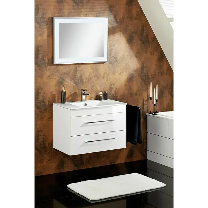 Camargue Stella K Waschtischunterschrank - 79,4 x 48,8 x 55 cm, Ohne Beleuchtung, Weiß - Elegantes Badezimmer-Interieur mit einem stilvollen weißen Waschtisch mit zwei Schubladen und einem beleuchteten Spiegel an einer braunen Wand.