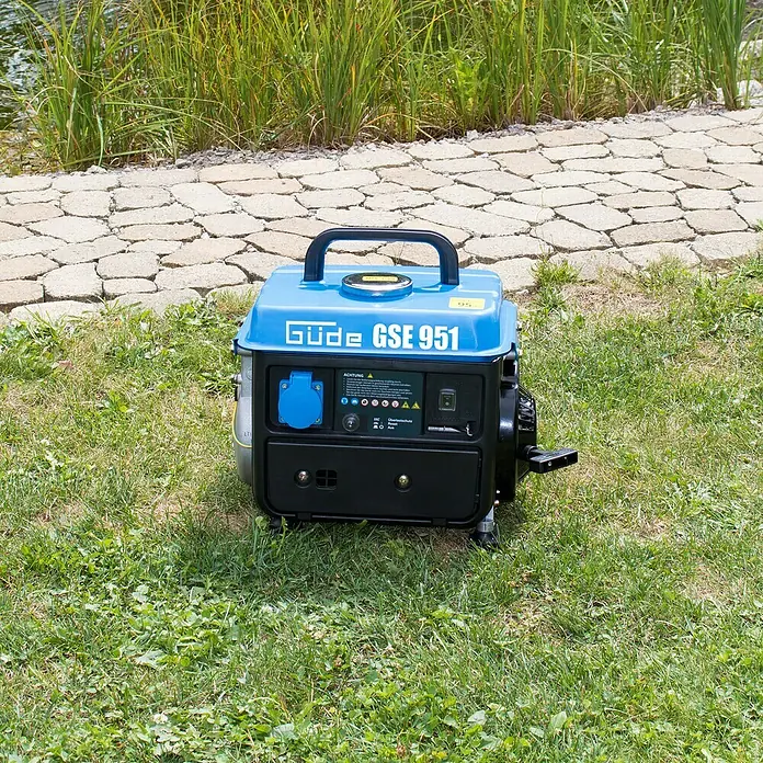 Güde Stromerzeuger GSE 951 - 720 W, Verbrauch: 0,5 l/h, Tankvolumen: 3,8 l - Aufnahme eines blauen Güde GSE 951 Stromerzeugers im Freien, der auf einer Wiese steht.