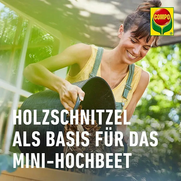 Compo Hochbeet-Grundfüllung Mini-Hochbeet Holzschnitzel - 16 l - Frau füllt Holzschnitzel von COMPO als Basis in ein Mini-Hochbeet.