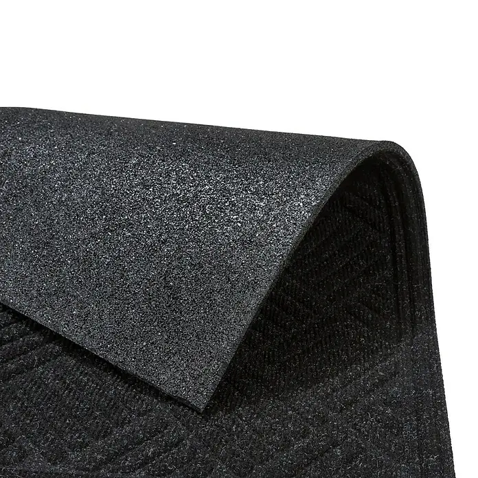 Fußmatte Nub Star - Anthrazit, 63 x 43 cm, 90 % Polyester, 10 % Polypropylen - Nahaufnahme einer schwarzen, strukturierten Gummimatte, die aufgerollt ist und die Textur und das Material hervorhebt.