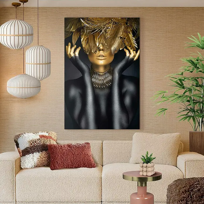 Reinders Glasbild Golden Feathers - Golden Feathers, B x H: 78 x 116 cm - Nahaufnahme eines Wohnzimmers mit einem stilvollen Gemälde einer Frau mit goldenen Federn als Kopfschmuck über einem beigen Sofa.