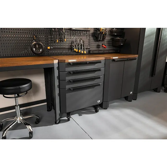 ToughBuilt Cajonera con ruedas - L x An x Al: 47 x 71 x 84 cm, Capacidad de carga: 181 kg, Número de cajones: 4 ud. - Primer plano de un banco de trabajo con cajones y pared de herramientas, ideal para bricolaje y talleres.