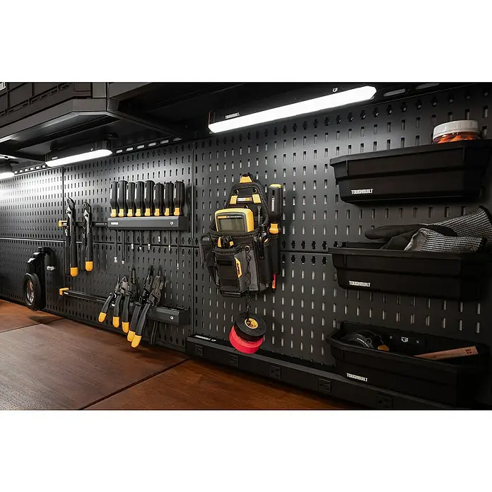 ToughBuilt Panel perforado - An x Al: 71 x 30 cm, 2 pzs. - Primer plano de una pared de herramientas organizada con soluciones de almacenamiento ToughBuilt, que muestra orden y eficiencia en un espacio.