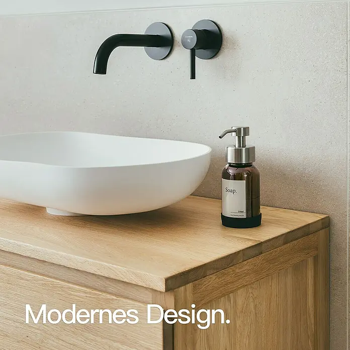 Designfabrik Hamburg Seifenspender - Edelstahl, Silber/Braunglas - Eine moderne Badezimmerarmatur mit Waschbecken und einer stilvollen Seifenspenderflasche aus braunem Glas.