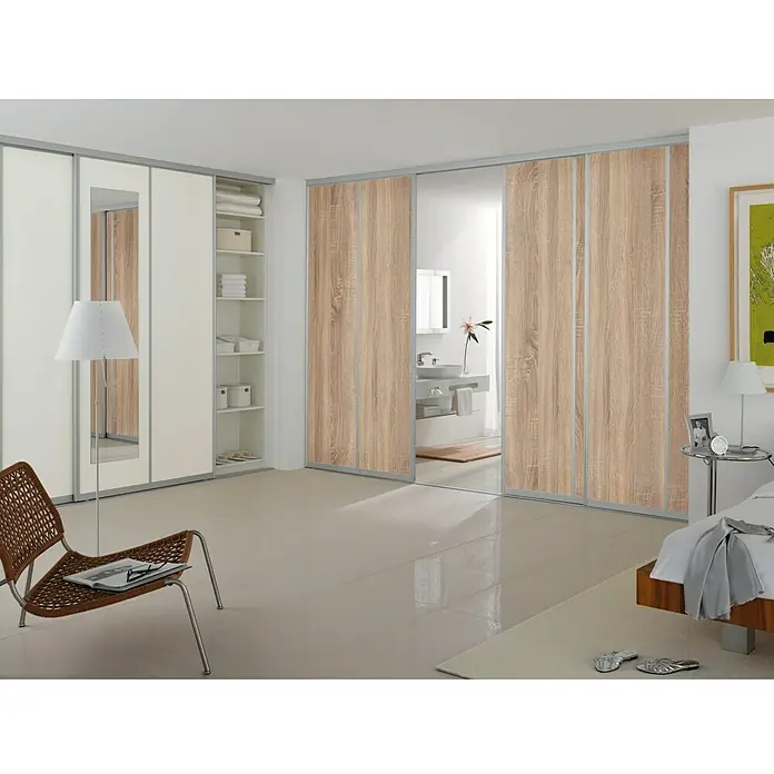 Room Plaza Easy Schiebetür-Bau-Set - Eiche geplankt/Eiche Trüffel, Farbe Beschlag: Silber - Ein Schlafzimmer mit einem großen Kleiderschrank mit Schiebetüren, die einen Blick ins Badezimmer freigeben.