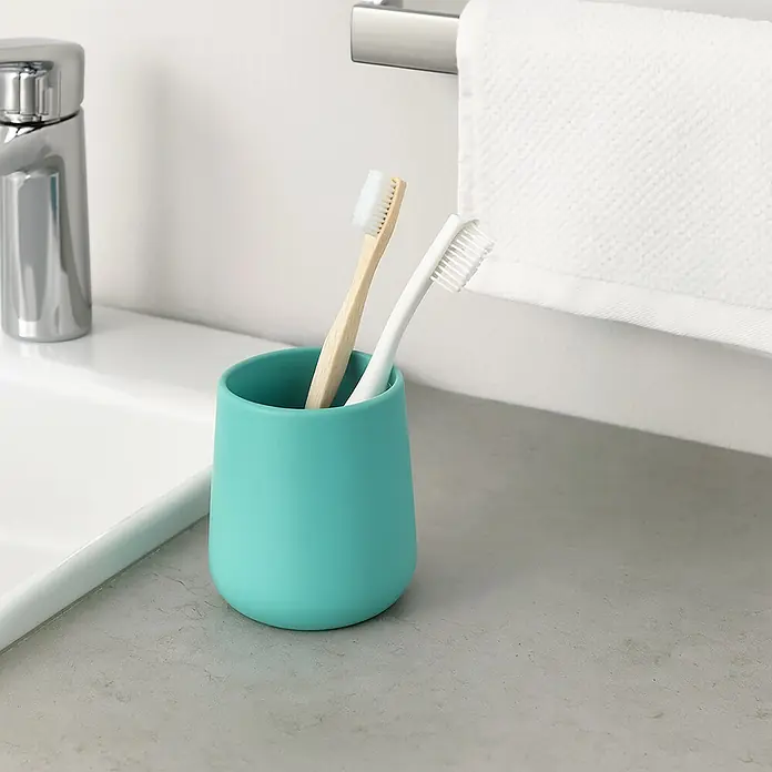 MSV Maonie Portacepillos - Ø x Al: 8,5 x 10 cm, Cerámica, Aqua - Primer plano de un portacepillos de dientes color verde azulado con dos cepillos de dientes, uno de madera y otro blanco, en un baño.