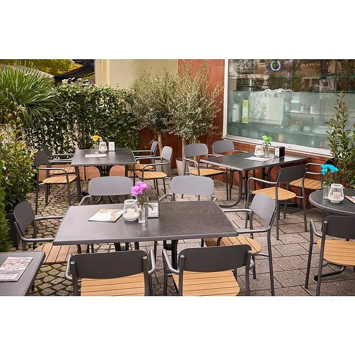 MFG Gartentisch Boulevard - L x B: 132 x 90 cm, Stahl, Mecalit, Schiefer, Klappbar - Aussenbereich eines Cafés mit Tischen und Stühlen, dekoriert mit Blumen.
