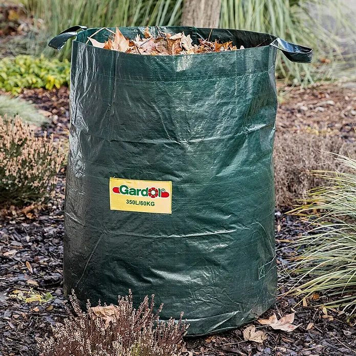 Gardol Saco para residuos del jardín - 350 l, Altura: 90 cm, Diámetro: 70 cm - Una bolsa de jardín verde de la marca Gardol, llena de hojas, está en el jardín. Tiene una capacidad de 350 litros y puede soportar hasta 60 kg.