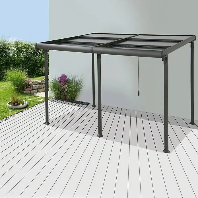 Sunfun Pérgola adosada Sera - An x Pr: 400 x 300 cm, Antracita, Aluminio - Un elegante cenador con estructura gris y techo transparente se alza sobre una terraza luminosa.