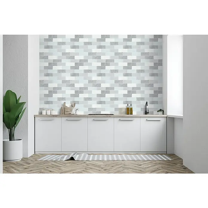 D-c-fix Ceramics Vinyltapete - Pastel Tiles, L x B: 4 m x 67,5 cm - Ein elegantes Kücheninterieur mit stilvollen weißen Schränken, einer Holzplatte und einer dekorativen Wand aus grauen Ziegeln.