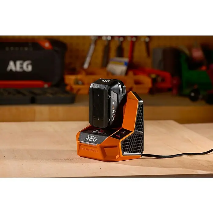 AEG Pro 18V Akku-Schnellladegerät 12A Turbo Charger -  - Nahaufnahme eines AEG 12A Turbo Ladegeräts mit eingesetztem Akku vor Werkstatthintergrund.