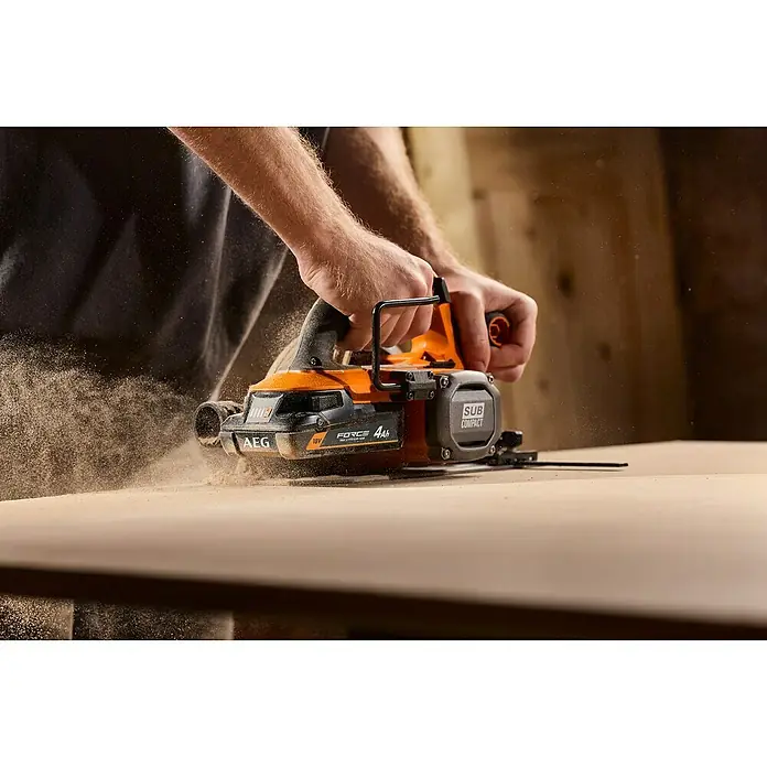 AEG Pro 18V Akku FORCE PROLITHIUM-ION™ - 4 Ah, Li-Ionen - Ein Handwerker benutzt eine AEG Tauchsäge, um ein Stück Holz zu schneiden, wobei Sägemehl aufwirbelt.