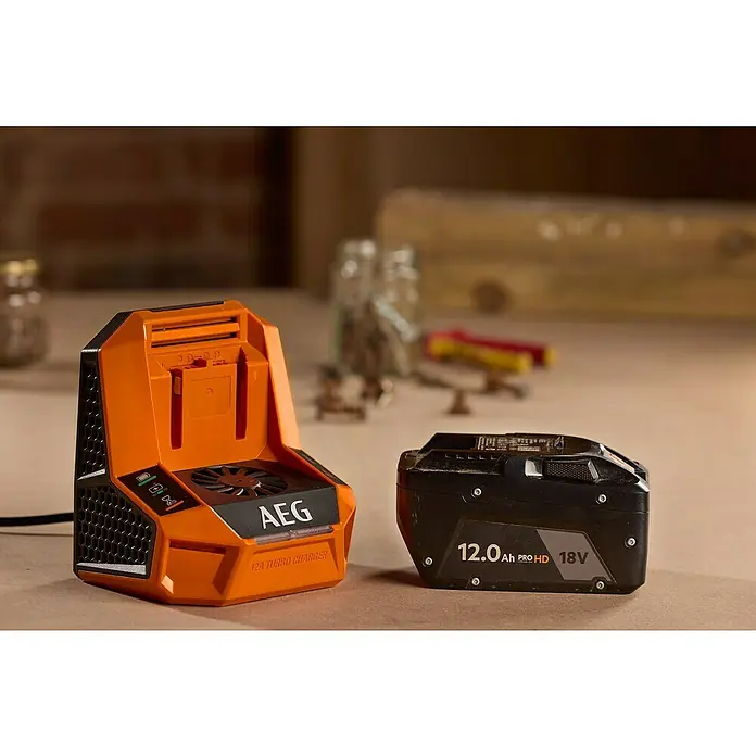 AEG Pro 18V Akku-Schnellladegerät 12A Turbo Charger -  - AEG 12A Turbo-Ladegerät in Orange und eine schwarze 18V Batterie mit 12.0Ah Kapazität auf einem Tisch.