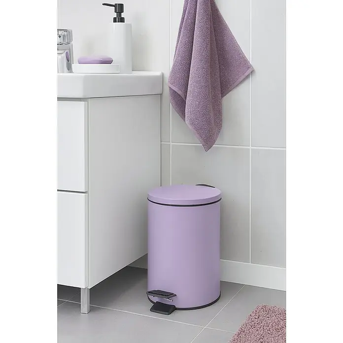 Spirella Cubo con pedal Adelar - 5 l, Acero inoxidable, Lavanda - Papelera de baño morada con pedal junto a un lavabo blanco y una toalla morada.