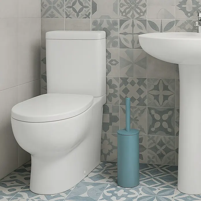 Spirella Conjunto de escobilla Akira - 9,5 x 9,5 x 40 cm, Acero inoxidable, Azul - Primer plano de un inodoro blanco junto a un escobillero de baño azul en un baño con azulejos estampados.