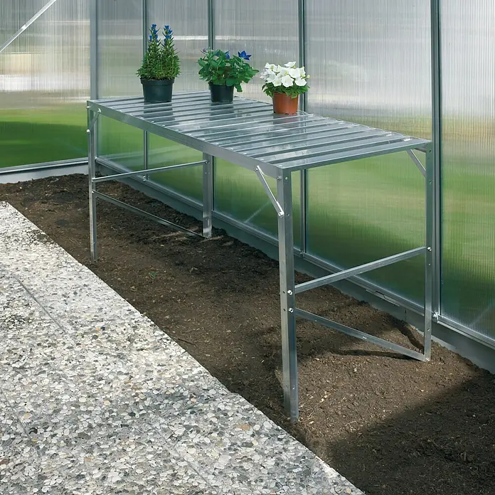 Vitavia Anzuchttisch I - 54 x 121 x 76 cm, Aluminium - Bild eines silbernen Arbeitstisches für Gewächshäuser mit drei Topfpflanzen darauf, der sich für die Gartenarbeit eignet.