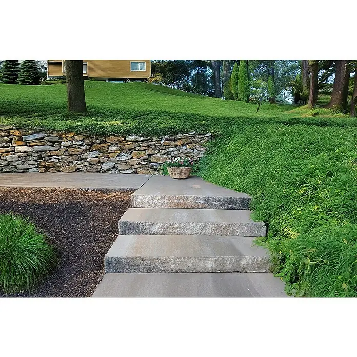 EHL Blockstufe - 50 x 35 x 15 cm, Muschelkalk, Beton - Landschaftsaufnahme mit Steinstufen, die zu einem Garten mit üppiger Vegetation und einer Blumenkorbdekoration führen.