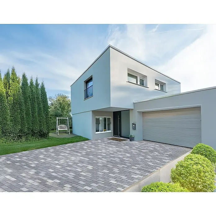 EHL Pflasterstein Slimstone - 18 x 12 x 5 cm, Grau-Anthrazit, Beton - Ein modernes Haus mit einer gepflasterten Auffahrt und einer Garage. Das Haus hat ein schlichtes, kubisches Design und helle Farben.