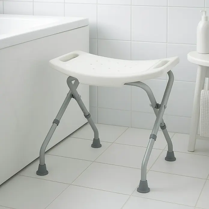 careosan Taburete de baño - 52 x 395 x 515 cm, Plástico, Ajuste de altura: 475 cm - 515 cm - Un taburete de ducha blanco plegable con patas grises ubicado en un baño con azulejos blancos y una bañera.