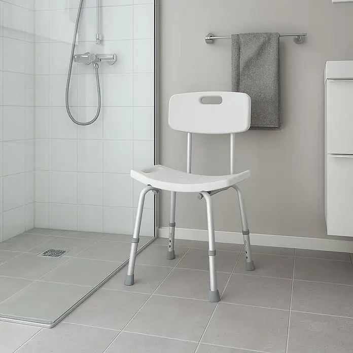 CM Baños Asiento para bañera BANQ05 - L x An x Al: 35 x 50 x 60 cm, Aluminio - Toma de una silla de ducha con respaldo en un baño. La silla de ducha es blanca con patas plateadas y gris en los pies.