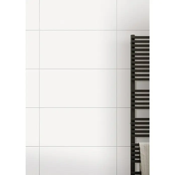 DryTile Wandfliese Palazzo Strukturiert Plast - 30 x 60 cm, Weiß, Glänzend - Nahaufnahme einer weißen, gefliesten Badezimmerwand mit einem schwarzen Handtuchwärmer, der an der Wand befestigt ist.
