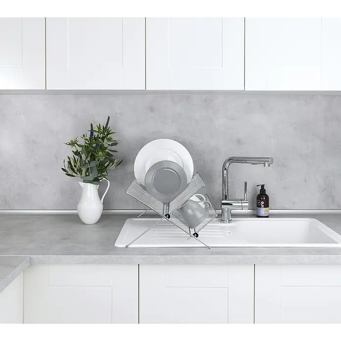 Wenko Abtropfgestell - L x B x H: 38 x 38 x 22 cm, Metall, Silber - Ein minimalistischer Geschirrständer aus Metall präsentiert ordentlich Teller und Tassen neben einem modernen Wasserhahn und einer stilvollen Spüle.