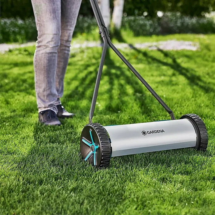 Gardena Comfort Spindelmäher 400 - Schnittbreite: 40 cm, 250 m² - Eine Gardena Handspindelmäher auf einem grünen Rasen im Garten, der von einer Person bedient wird.