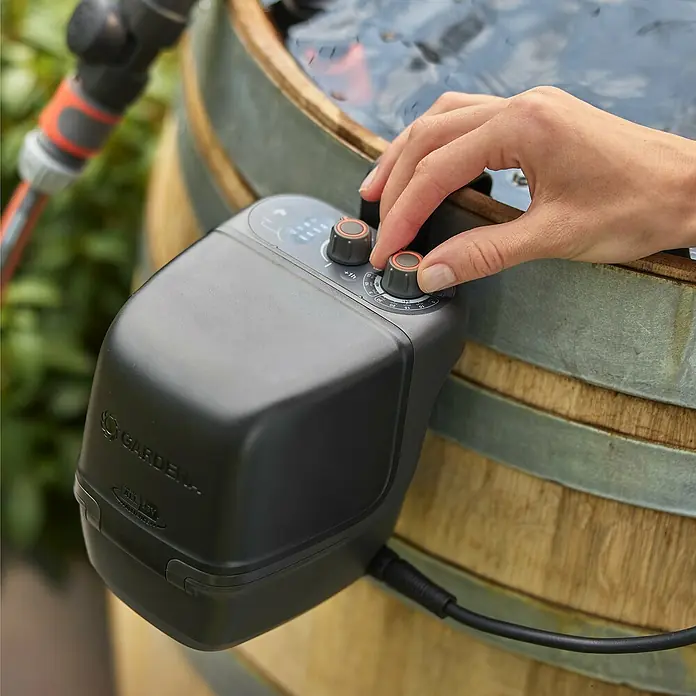 Gardena Power for All 18V Akku-Regenfasspumpe 2500 ComfortAutomatic - Ohne Akku, Max. Fördermenge: 2.400 l/h - Der GARDENA Regensensor electronic mit Drehknöpfen zur optimalen Bewässerungssteuerung, montiert an einem Fass.