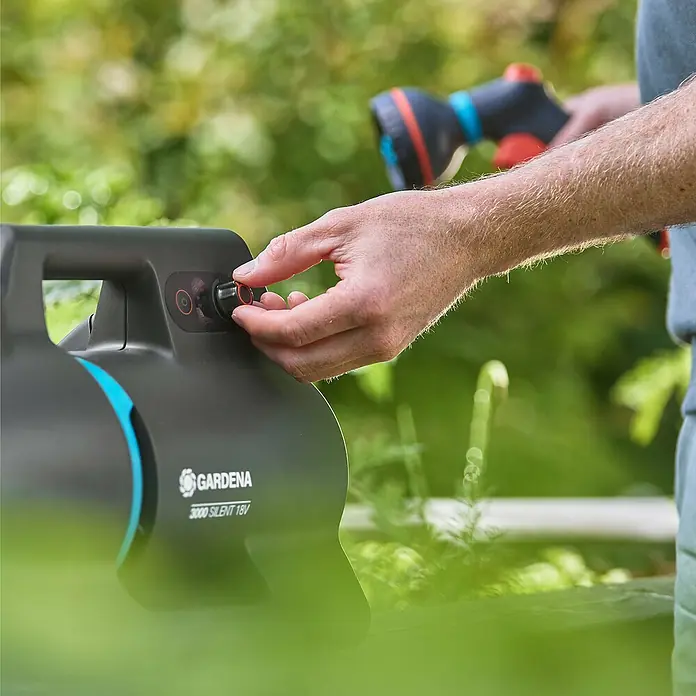 Gardena Power for All 18V Akku-Gartenpumpe 3000 Silent - 18 V, Li-Ionen, Ohne Akku, Max. Fördermenge: 3.000 l/h - Bild einer Gardena 3000 Silent 18V Gartenpumpe, die von einer Person bedient wird. Nahaufnahme der Bedienung am Gerät.