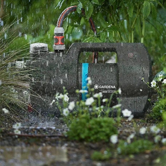 Gardena Hauswasserautomat 4600 Silent - Max. Fördermenge: 4.600 l/h, Max. Druck: 4 bar - Bild einer Gardena 4600 Silent Gartenpumpe im Einsatz, die mit einem Schlauch verbunden ist und Wasser pumpt. Perfekt für die Gartenbewässerung.