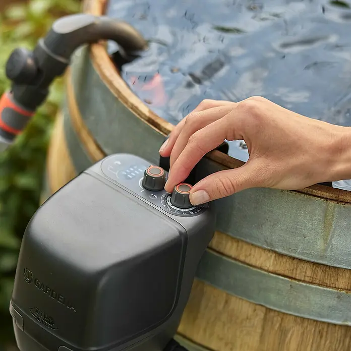Gardena Power for All 18V Akku-Regenfasspumpe 2600 Comfort - Ohne Akku, Max. Fördermenge: 2.600 l/h - Nahaufnahme eines Gardena Bewässerungssteuerung an einem Fass, mit einer Hand, die den Regler einstellt.