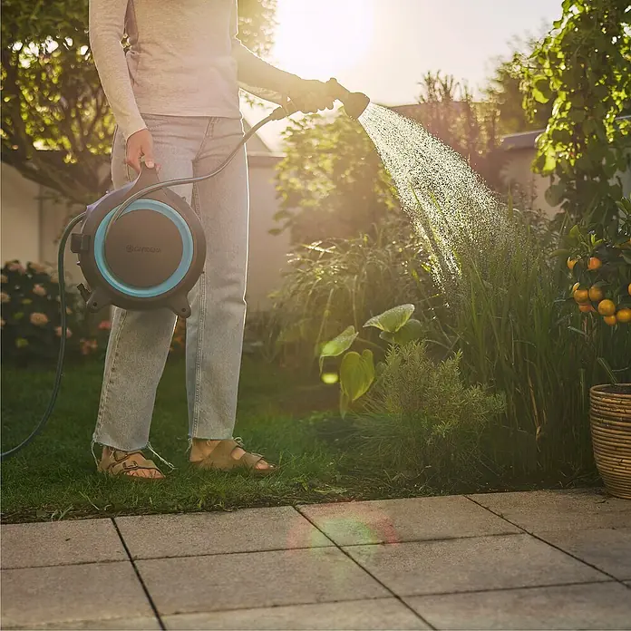 Gardena Schlauchbox MoveMatic - Schlauchlänge: 12,5 m - Eine Frau bewässert ihren Garten mit einer Gardena Schlauchtrommel, die für Komfort und einfache Nutzung sorgt.