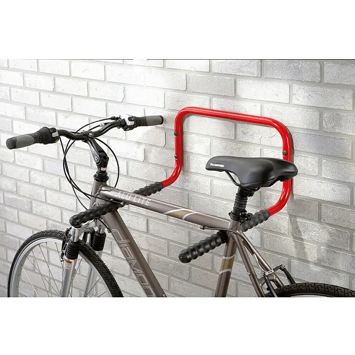 Aparcamiento de bicicletas - L x An x Al: 50 x 43 x 27 cm, Acero - La imagen muestra un portabicicletas montado en una pared de ladrillos, sujetando una bicicleta de forma segura. El estante rojo es una solución.