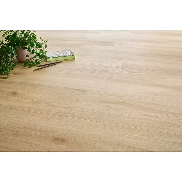 Vinylboden SPC XL - Eiche Harlow, Landhausdiele, 1.511 x 229 x 6,3 mm - Heller Holzboden mit natürlicher Maserung, verlegt im Wohnbereich. Dekorative Elemente wie Topfpflanze und Stifte ergänzen den Raum.
