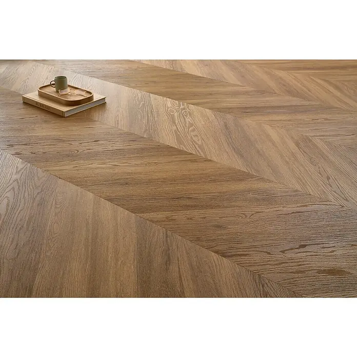 Vinylboden SPC Chevron - Jersey Eiche, 120 x 600 x 4,5 mm - Detailansicht eines eleganten Holzfußbodens im Fischgrätmuster, der Wärme und Stil in jeden Raum bringt.