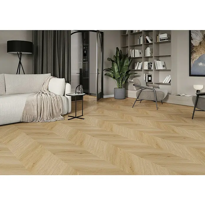 Vinylboden SPC Chevron - Arvada Eiche, 120 x 600 x 4,5 mm - Ein Wohnzimmer mit einem hellen Sofa, einem Beistelltisch und einem Bücherregal. Der Boden ist mit hellem Fischgrätparkett ausgelegt.