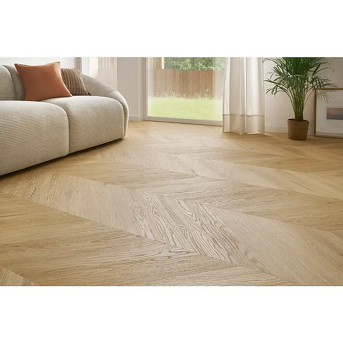 Vinylboden SPC Chevron - Arvada Eiche, 120 x 600 x 4,5 mm - Nahaufnahme eines hellen Holzfußbodens im Fischgrätmuster, der eine warme und einladende Atmosphäre schafft. Ideal für moderne Wohnräume.