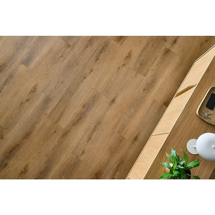 Vinylboden SPC Silent - Garda Eiche, Landhausdiele, 1.220 x 229 x 5,3 mm - Ein Bodenbelag in Holzoptik, ideal für Wohnräume, kombiniert mit einem hellen Holzmöbelstück, das eine moderne und einladende Atmosphäre schafft.