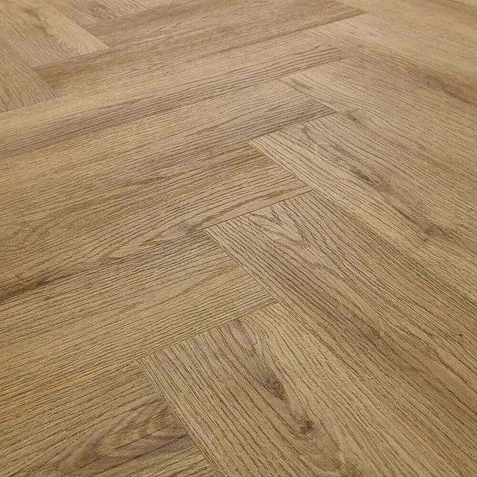 Vinylboden SPC Herringbone - Garda Eiche, Fischgrät, 148 x 592 x 4,5 mm - Nahaufnahme eines hellbraunen Holzfußbodens im Fischgrätenmuster, der eine warme und klassische Atmosphäre erzeugt.