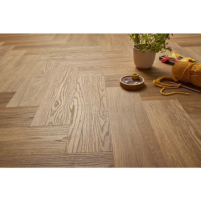 Vinylboden SPC Herringbone - Jersey Eiche, Fischgrät, 148 x 592 x 4,5 mm - Einladendes Interieur mit elegantem Vinylboden in Holzoptik, ergänzt durch eine Zimmerpflanze und Handarbeitsutensilien für eine warme Atmosphäre.