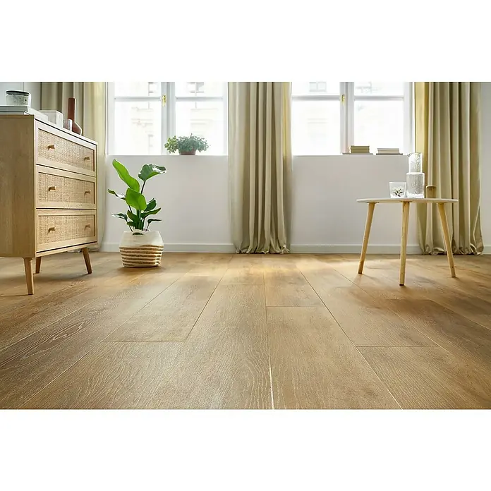 Vinylboden SPC XL - Eiche Sierra, Landhausdiele, 1.511 x 229 x 6,3 mm - Nahaufnahme des Laminatbodens in einem hellen Raum, der die Textur und das Design hervorhebt, zusammen mit Möbeln und Pflanzen.