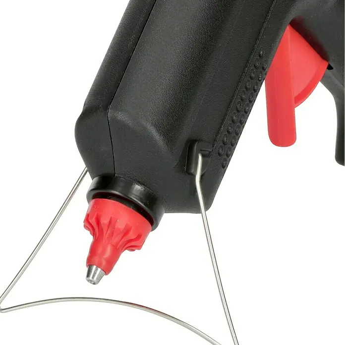 Alpha Tools Heißklebepistole - 500 W, Durchmesser Klebepatrone: 11 mm - 12 mm - Nahaufnahme einer schwarzen Klebepistole mit roter Düse und rotem Abzug, die auf einem silbernen Ständer steht.