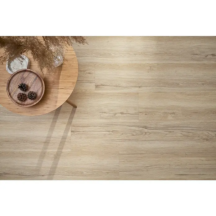 Vinylboden SPC Silent - Wildwood Eiche, Landhausdiele, 1.220 x 229 x 5,3 mm - Nahaufnahme von natürlichem hellem Holzfußboden mit einem runden Tisch, der mit dekorativen Elementen geschmückt ist, um eine gemütliche Raumatmosphäre zu schaffen.