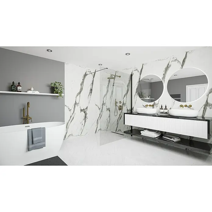 Wetwall Wandpaneel Elite - 16 x 242 cm, Calacatta Statuario, Abgerundete Kante - Ein Badezimmer mit Marmorwänden, einer Badewanne, zwei runden Spiegeln und einem Doppelwaschtisch mit Stauraum.