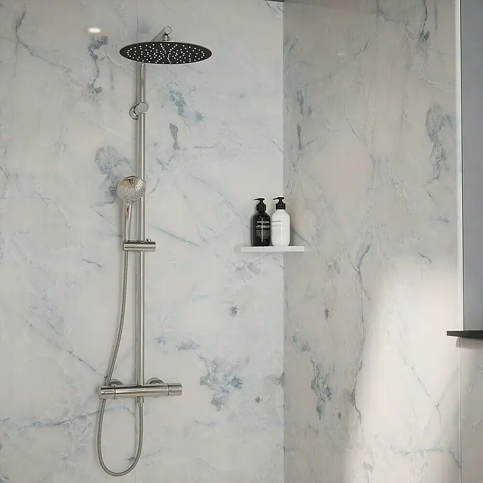 Wetwall Wandpaneel Elite - 16 x 242 cm, Onyx Oro, Abgerundete Kante - Nahaufnahme einer Duschkabine mit einer modernen Duscharmatur und zwei Flaschen auf einem Regal, die ein stilvolles Badezimmerdesign zeigen.